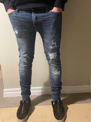 Jack & Jones Skinny Fit Liam jeans - Modellen är för små för mig de är där för ja säljer de. Men de passar jävligt bra på någon lite mindre runt 170 tills 175. Säljer ett par mörkblå skinny fit jeans från Jack & Jones, modell Liam. De har slitna detaljer och hål på benen för en cool, trendig look. Klassisk femficksdesign och stretchigt denimtyg som sitter tajt längs benen.