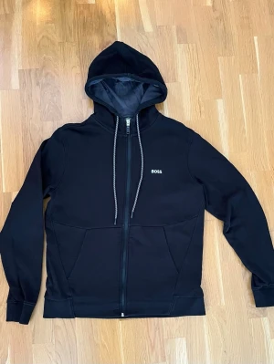 Svart Boss Hoodie  - Säljer en svart Hoodie  boss använd ett fåtal gånger, jätte fint skick. Storlek M 
