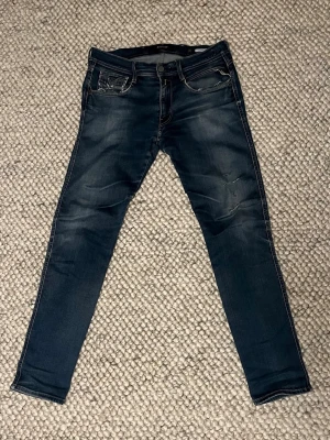Replay Anbass jeans  - Replay Anbass jeans i mörkblå med slitningar. Materialet är stretchigt och är supersköna att använda. Skick 9/10, storlek: W31 L32