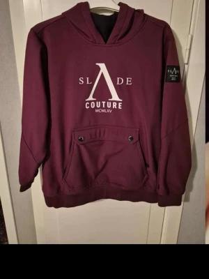 Svarta skidbyxor från Slade och jacka  - Svarta skidbyxor från Slade med logga på benet och praktiska fickor på sidorna, lite bootcat passform. Vinröd skidjacka från slade med stor ficka på magen. Ficka på ena armen för skidpass, passform som en husse min finns drajskedja för att få på sig enklare. STORLEK: byxorna - 160 jackan - 170. 800 kr för båda och 500 för varje. 2000 nypris 