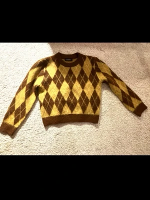 Stickad Tröja från Stradivarius - Stickad tröja i gult och brunt mönster från Stradivarius. Storlek Small (S).