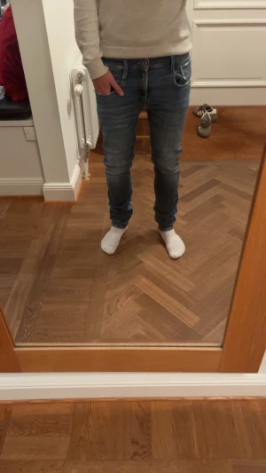 Replay Anbass blå jeans herr - Säljer ett par Replay Anbass jeans i klassisk blå tvätt med snygga slitningar och detaljerade sömmar. Modellen har fem fickor, smal passform och normal midja. Materialet är mjukt jeans-tyg med stretch för extra komfort. Perfekt för dig som gillar stilrena och moderna jeans. Storlek 29W och 32L