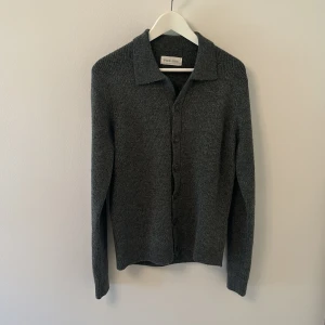 stickad kofta från pier one  - Snygg mörkgrå stickad kofta från pier-One med klassisk krage och knäppning framtill. Långärmad och i mjukt material som passar perfekt till lager-på-lager. Enkel och stilren design som funkar till många outfits.