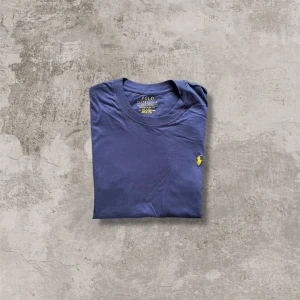 Ralph lauren T-shirt, Marinblå - Schyst Ralph lauren T-shirt Mörkblå med gul logga Storlek L Hör av er vid fler frågor eller likande ☺️🙏🏻