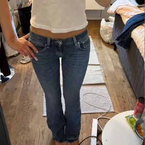 Blå bootcut jeans  - Snygga blå jeans med bootcut passform och coola broderade detaljer på bakfickorna. Jeansen har klassisk femficksdesign, låg midja och är gjorda i mjukt denimtyg. Helt nya oanvända bara testade eftersom jag köpa en för liten storlek. Str 36, super snygga jeans! Nypris 500kr