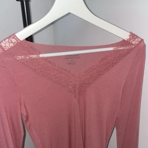  Intimissimi topp - Superfin långärmad topp från Intimissimi i en mjuk, ljusrosa nyans. Toppen har v-ringning med vacker spetsdetalj längs halsringningen och axlarna. Aldrig använd, bara testad. Kan även visa hur den sitter på
