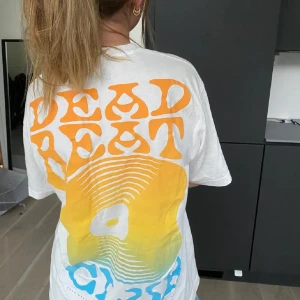 Oversized T-shirt - Vit t-shirt med tryck både fram och bak. Stort grafiskt motiv på ryggen och mindre logga på bröstet. Perfekt för chill och streetstyle. Pris kan diskuteras vid snabb äffär!