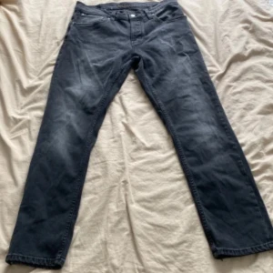 Nudie jeans grim Tim - Säljer ett par tvär feta mörk gråa Nudie jeans. Storlek 33/30. Jeansen är väll använda och inga defekter. Vid fler fårgor och funderingar är de bara att höra av sig