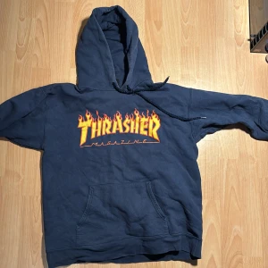 Thrasher hoodie  - Mörkblå thrasher hoodie i storlek M, använd och därför har den ett snyggt åldrat tryck, inga fläckar eller slitningar förutom att snörerna är lite slitna.