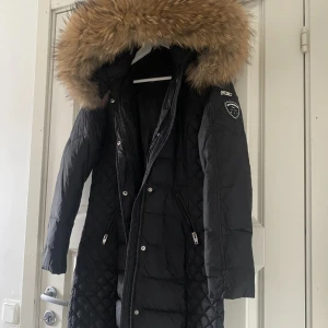 Svart lång dunjacka Rockandblue - Säljer min fina rockandblue jacka med päls, den är i storlek 36. säljer pågrund av att har en annan jacka och denna jacka har blivit lite stor. kom privat för flera frågor elr bilder! - priset går diskuteras!