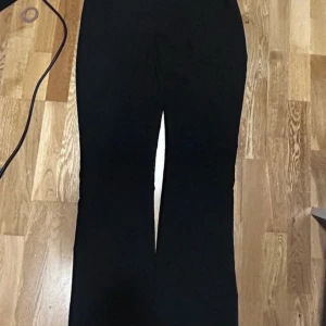 Svarta bootcut byxor i bomull - Snygga svarta byxor med bootcut-silhuett och klassisk passform. Tillverkade i mjuk bomull som känns skön mot huden. Perfekta för dig som gillar en stilren look med lite utsvängda ben. Passar till sneakers eller boots.