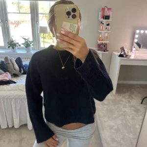 Mörkblå stickad croppad tröja - Mysig mörkblå stickad tröja med croppad passform och långa ärmar. Tröjan har en enkel design med ribbade muddar vid ärmslut och nederkant. Perfekt för lager-på-lager och chill dagar. Den är från Gina Young och är i storlek 146-152 men är som en xs. Passar mig som är ca 163