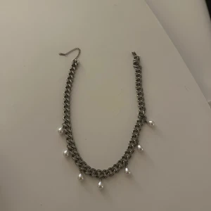 Chunky silverhalsband med pärlor - Stilrent halsband i chunky silverfärgad metallkedja med hängande vita pärlor. Kedjan har breda länkar och justerbar längd. Knappt använt!💘