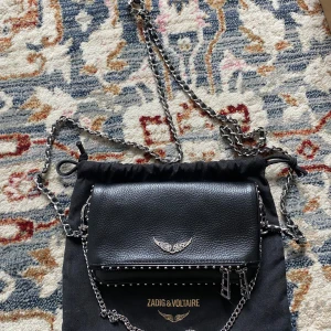 Zadig & Voltaire väska - Supersnygg axelarmsväska med avtagbara band och tre fickor där man får plats med alla sinna vardagliga saker. Väskan är endast använd ett fåtal ggr och är i mycket bra skick. Nypris 3300kr, mitt pris går att diskutera.💗