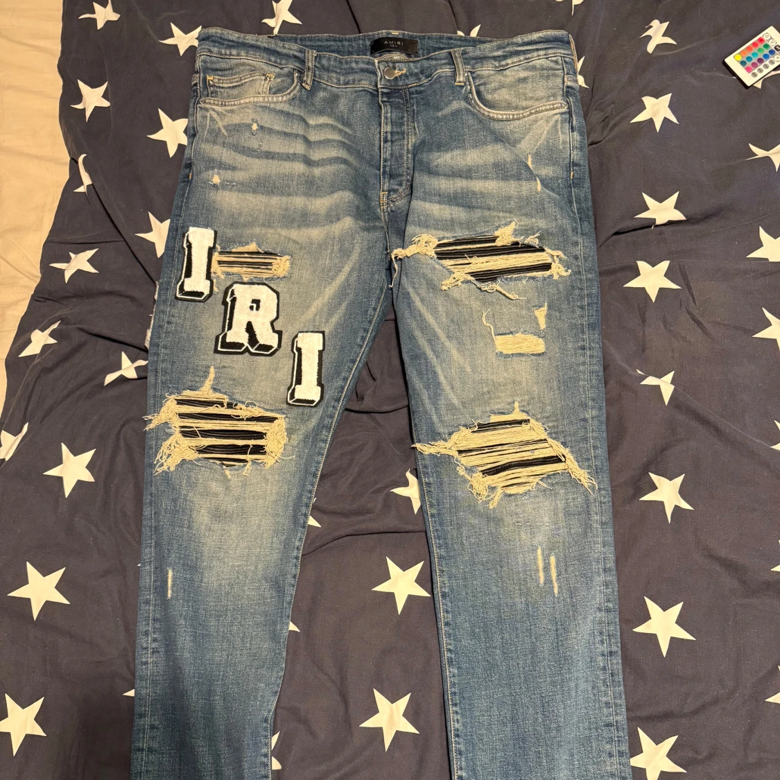 Blå ripped jeans från Amiri med patchar
