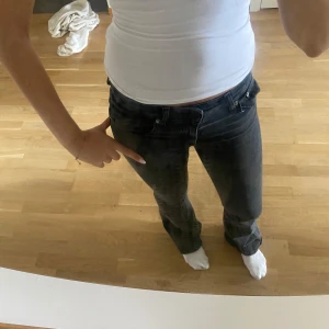 Lågmidjade utsvängda grå/svarta jeans - Storlek Xs (32) Full lenght. Jag är 164-165 cm lång! Men passar längre🩷