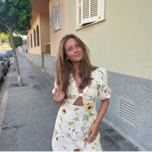 Blommig kortklänning med puffärm - Superfin ljus kortklänning från H&M med blommigt mönster i grönt och gult. Klänningen har puffärmar, v-ringning, knyt i ryggen och en snygg cut-out framtill. 