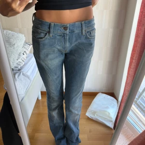Blå bootcut jeans från Ferrarina - Säljer ett par klassiska blå jeans från Fornarina, bootcut och lågmidjade. Tyvärr lite för stora på mig. Innerbenslängd ca 85 cm och midjemått 42 cm
