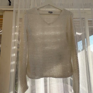 Vit stickad tröja från Lindex - Säljer en vit stickad tröja från Lindex i storlek M. Tröjan har v-ringning och är långärmad med ett luftigt, grovmaskigt stickat material. Perfekt för lager-på-lager och passar snyggt till jeans eller kjol.