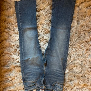 Tommy Jeans crop flare jeans blå - Snygga blå jeans från Tommy Jeans med croppad flare-modell och råa, fransiga benslut. Klassisk femficksdesign, normal passform och tydlig logga bak. Jeansen är i kraftig denim och har en cool vintagekänsla.