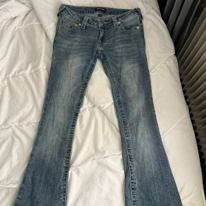 True Religion bootcut jeans  - Säljer dessa super snygga och populära true religion jeansen i modellen Ultra low rise joey flare. Endast använda ett fåtal gånger och den lilla skav defekten längst ner på ett av benen är pga de var lite långa på mig. Storlek W25 det motsvarar XS. 