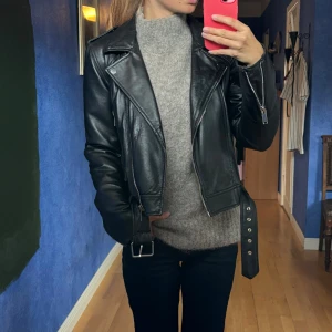 Svart skinnjacka med bälte och dragkedjor - Cool skinnjacka från Zara! Köp för över 1000kr (inte helt säker på exakta priset)  den är av bra kvalitet! 