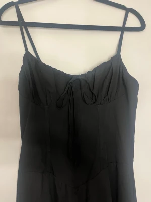 Svart långklänning med smala axelband - Svart långklänning från Shein i strl XS 💕Super fin till sommaren!! Kommer inte till användning.