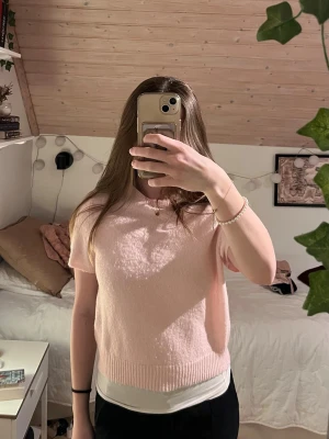 Ljusrosa kortärmad stickad tröja - Söt stickad t-shirt från HM. Storleken är M, dock är jag XS/S och har därför en något större passform. Den är relativt tunn fast har skönt material