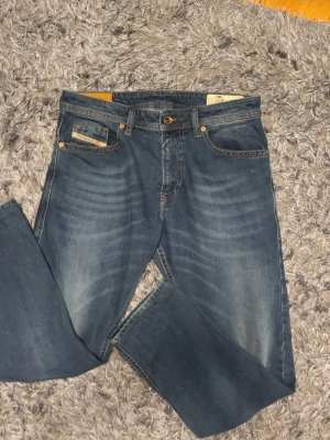 Diesel Thommer Slim-Skinny Jeans – W31 L32 - Klassiska blå Levi's 501 jeans med rak passform och subtila slitningar på låren. Jeansen har fem fickor, normal midja och är tillverkade i tåligt denimtyg. Perfekta för en avslappnad och tidlös stil.