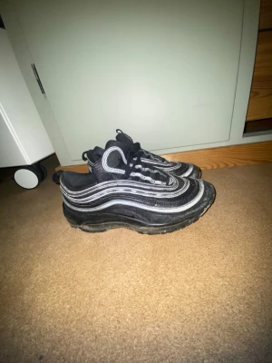 Nike Air Max 97 svart - Man ser att dom är använda men annars bra skick dom har reflex som ni ser på bilderna med blixt dom är strl 40 och pris kan diskuteras 
