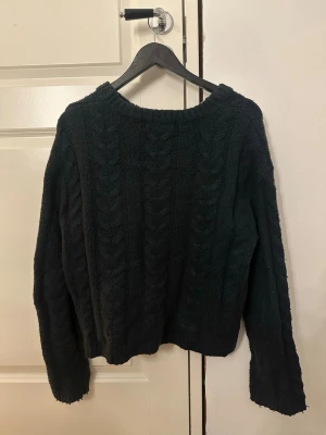 Svart kabelstickad tröja 157 - Mysig svart kabelstickad tröja från 157 i storlek XS. Tröjan har ett klassiskt flätmönster, rund halsringning och långa ärmar. Perfekt för dig som gillar en enkel men ändå stilren look till hösten eller vintern. Välanvänd men utan några defekter! Sitter mer som en S än Xs då den blivit uttöjd 