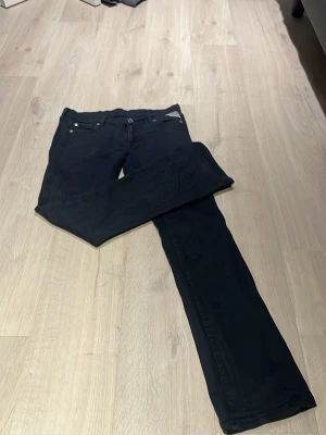 Svarta Replay jeans straight fit - Säljer ett par svarta jeans från Replay med klassisk femficksmodell och raka ben. Jeansen har snygga detaljer på bakfickorna och en läderpatch i midjan. Perfekta till en avslappnad streetstil. säljer pga inte passar mig längre. finns ett litet hål innanför byxan syns knappt, men går att sy. 😇❤️