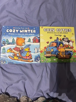 Cozy Winter & Cozy Cuties målarböcker - Två mysiga och gulliga målarböcker: Cozy Winter med vintertema och Cozy Cuties med söta djur och bilar. Båda har färgglada omslag med tecknade djur i olika miljöer. Perfekta för dig som gillar att färglägga och koppla av.