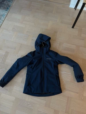 Mörkblå vindjacka från Peak Performance - Lätt fodrad skid jacka från PeakPreformance. Mörkblå i storlek M