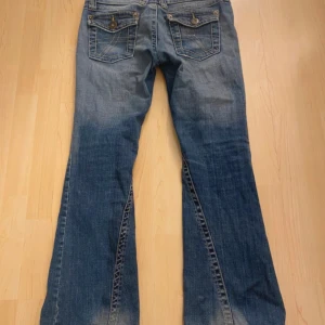 Lågmidjade bootcut jeans  - Jättesnygga lăgmidjade bootcut jeans med coola fickor! Storlek: M (lappar är urtvättade så ser ingen storlek, detta ar min uppskattning). • Mått: se bilder •Skick: bra (smutsiga fläckar vid hälarna, kan nog gå bort med rätt medel i tvätt, jag kan skicka bild)