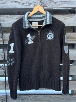 Ull Kofta Archive Grisch Vintage - Riktigt snygg vintage kofta i 100% ull🔥 Storlek M men har krympt lite och passar mer som en XS eller mindre S. Väldigt fint skick, enda defekten är lite smuts på baksidan av trycket (sista bilden) men är inget som jag märkt innan jag tog kort. Riktigt eftertraktat plagg! Hör gärna av er vid funderingar🙌🏻