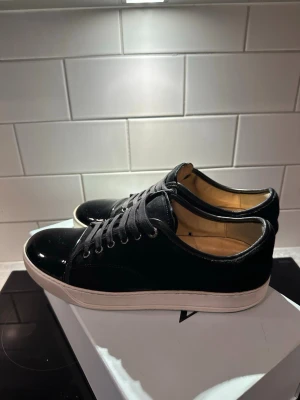 Svarta sneakers från Lanvin - Snygga svarta sneakers från Lanvin. De är i bra skick 8/10. De kommer med allting originalt såsom dustbag och extra skosnören. 