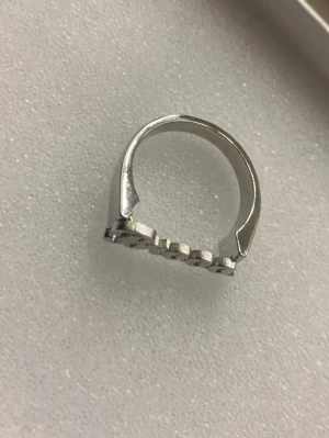 Silverfärgad ring från fine jewelry - Säljer en cool silverfärgad ring med texten 'brooo' i skrivstil framtill. Ringen har en modern och stilren design som sticker ut. Ingen synlig märkning.