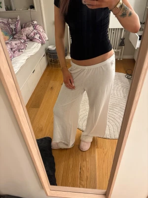 Vita vida mjukisbyxor  - Mysiga och luftiga vita mjukisbyxor med resår i midjan. Byxorna har en lös passform och är tillverkade i ett mjukt, lätt material som passar perfekt för hemmamys. Perfekta att kombinera med en enkel topp eller hoodie. Är i storlek M