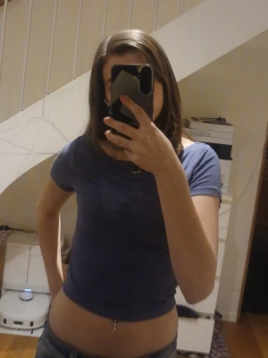 Blå topp med kort ärm - En enkel och stilren blå croppad topp med korta ärmar och rund halsringning. Perfekt att matcha med jeans eller kjol för en avslappnad look.