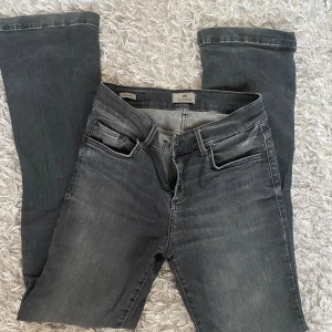 Grå jeansbyxor LTB - Säljer ett par grå jeansbyxor med en klassisk femficksdesign. Byxorna har en smal passform och är perfekta för en stilren look. De är tillverkade i ett bekvämt material som ger en snygg siluett.