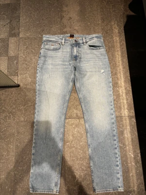 Jeans Hugo boss - Schyssta jeans från hugo boss i modell delaware Slimfit med diverse slitningar. Helt oanvända då dem inte riktigt passade mig. Ny pris= 1 799kr