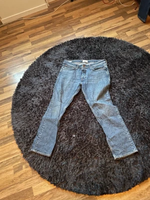 Jack and jones slim straight blå jeans  - Klassiska blå jack and jones slim straight jeans med rak passform och fem fickor. Jeansen har knappgylf och är tillverkade i slitstark bomullsdenim. Perfekta för dig som gillar tidlös stil och vill ha ett par ikoniska jeans i garderoben. 33/30 i storleken, priset kan diskuteras vid snabb affär 