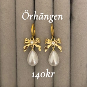 Guldiga örhängen med rosett och pärla - Par 