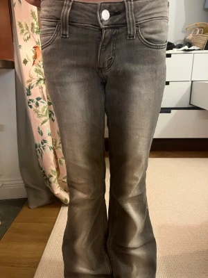 Svarta/gråa bootcut jeans  - Snygga grå bootcut jeans från weekday i st 34-36 kommer inte riktigt ihåg . Jeansen har en knappstängning och bälteshällor. Perfekta för en basis outfit.