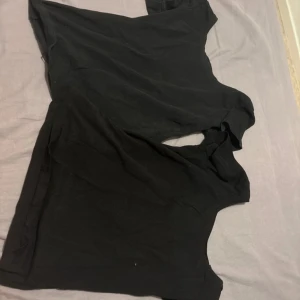 Svart ärmlös t-shirt från 157 - Två svarta t-shirts från 157 i storlek xs och s. Modellen är ärmlös med rund halsringning och har en enkel, clean look. Materialet är mjuk bomull som känns skönt mot huden. Perfekt för dig som gillar basic och stilrena plagg.