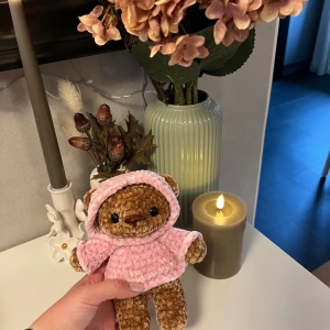 Virkad björn i rosa hoodie🩷🤎 - Denna söta björnen har jag virkat med polyester garn från Niimo, garnet Alfred🤎🩷 Det är ett väldigt mjukt och skönt garn🤎 Man får tänka på att man kan inte dra i säkerhetshögonen hur mycket som helst (speciellt små barn) dom skulle kunna lossna, dom sitter bra men jag vill ändå tillägga risken finns🩷    ✨ Detaljer: – Handvirkad med mjukt garn från Niimo – Ca 20cm lång – Brunbjörn med rosa hoodie – Hårda ögon  – Unik bara en finns i denna färgkombination (ännu) - Handgjord med kärlek🩷🤎 - Jag som 