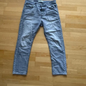Grå jeans från Jack & Jones, 30/30 - Snygga grå jeans från Jack & Jones i klassisk femficksmodell. Jeansen har rak passform och normal midja, tillverkade i mjukt jeanstyg. Perfekt för dig som gillar en enkel och stilren look. Storlek 30/30. Bilden är skrynklig 