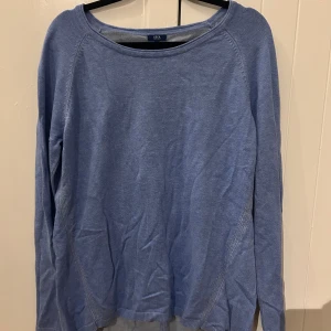 Ljusblå stickad tröja från Cecil - Ljusblå stickad tröja från Cecil med rund hals och långa ärmar. Tröjan har en enkel design med diskreta sömmar längs sidorna och en stickad detalj på ryggen. Perfekt för dig som gillar en chill och stilren look.