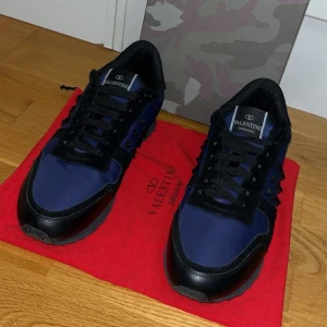 Valentino Garavani Rockrunner  - Snygga Valentino Garavani Rockrunner sneakers i mörkblått och svart med coola nitar på sidorna. Skorna har en mix av skinn och mocka. Box och dustbag ingår!🙌🙌 Hör av er vid minsta funderingar! Priset är inte hugget i sten